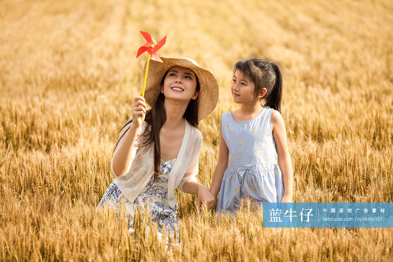 快乐的母女俩在麦田里玩耍