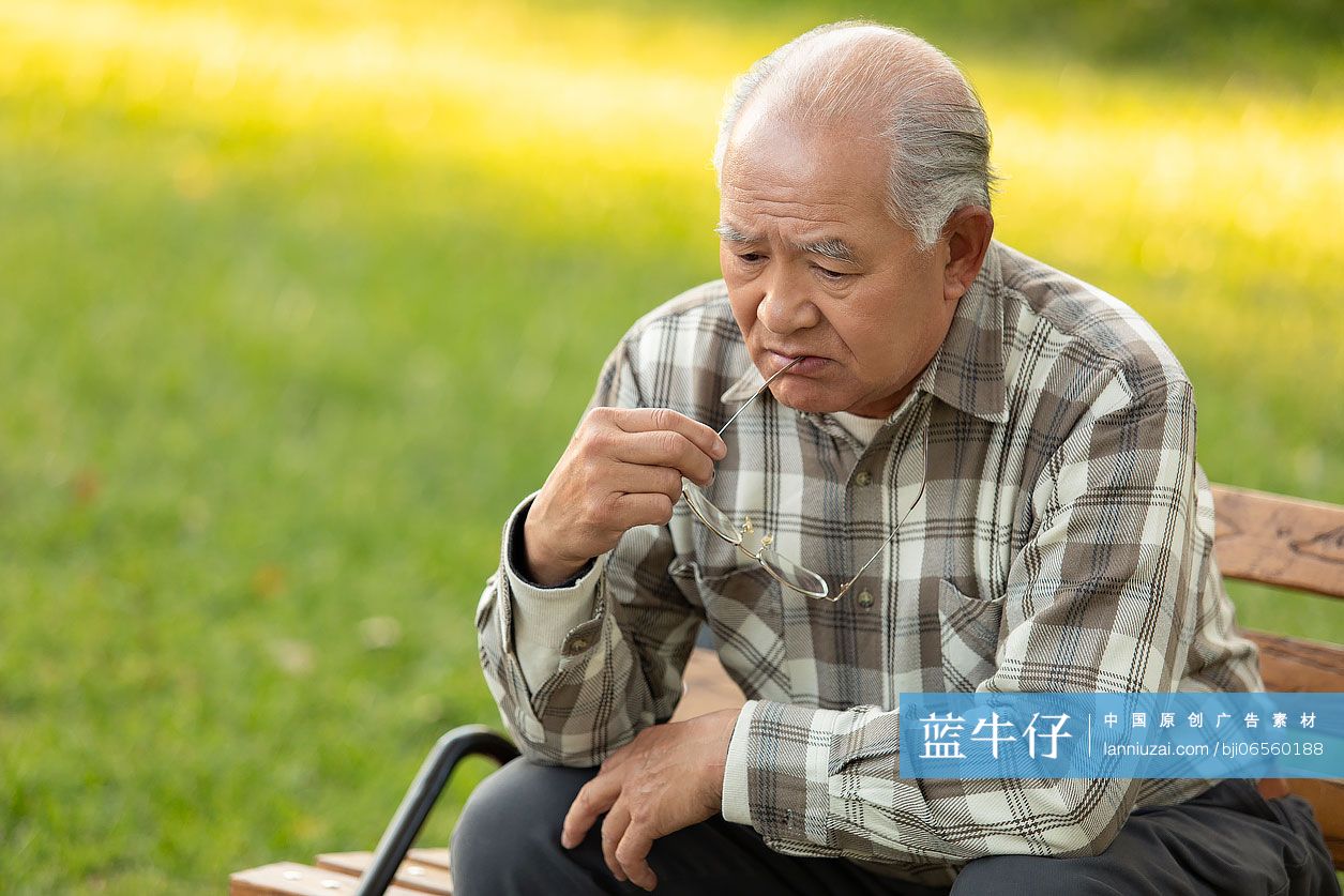 孤独的老人坐在公园长椅上