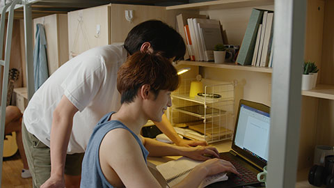 年轻大学生在宿舍使用笔记本电脑