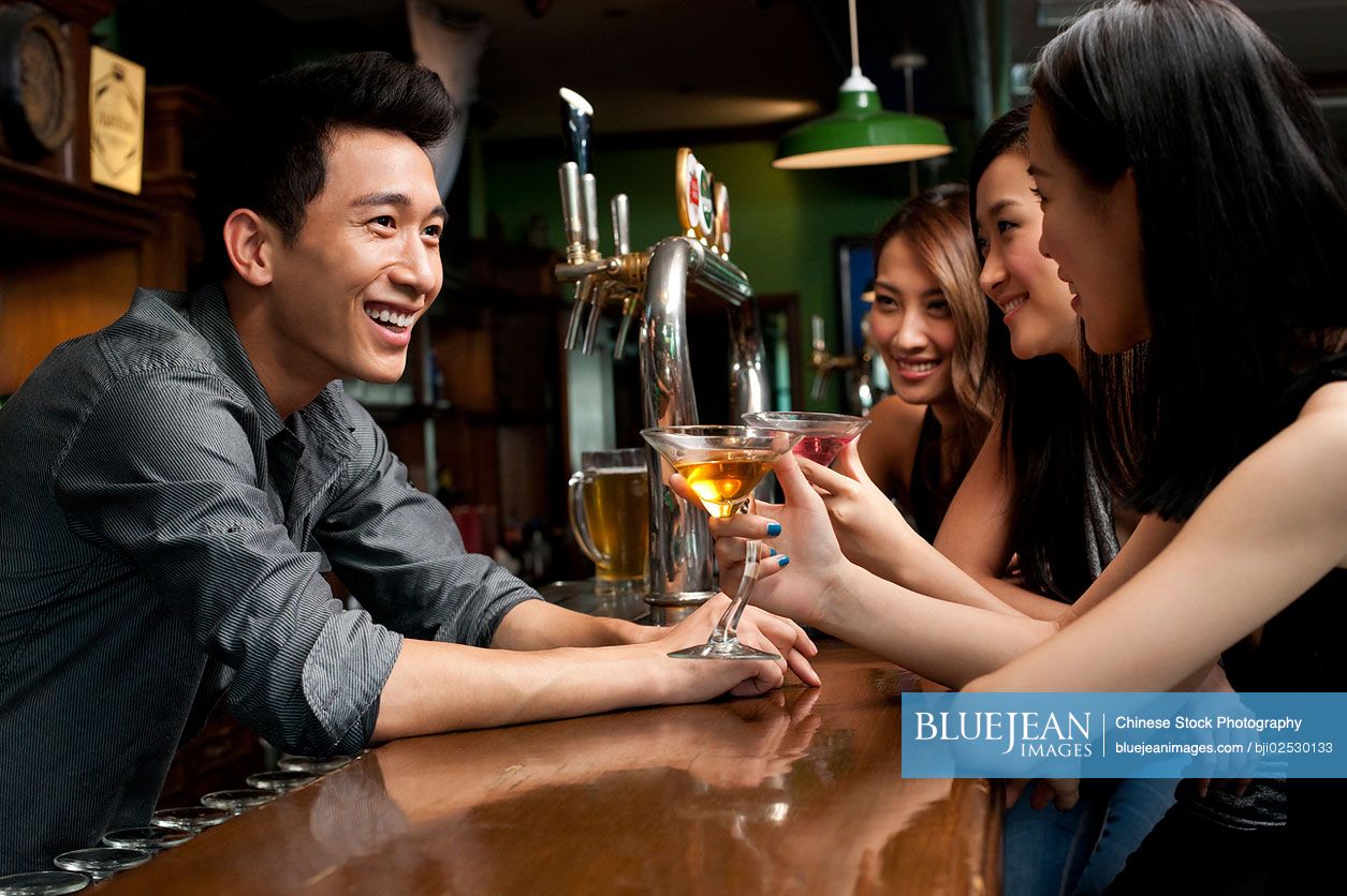 Chinese bartender talking with customers