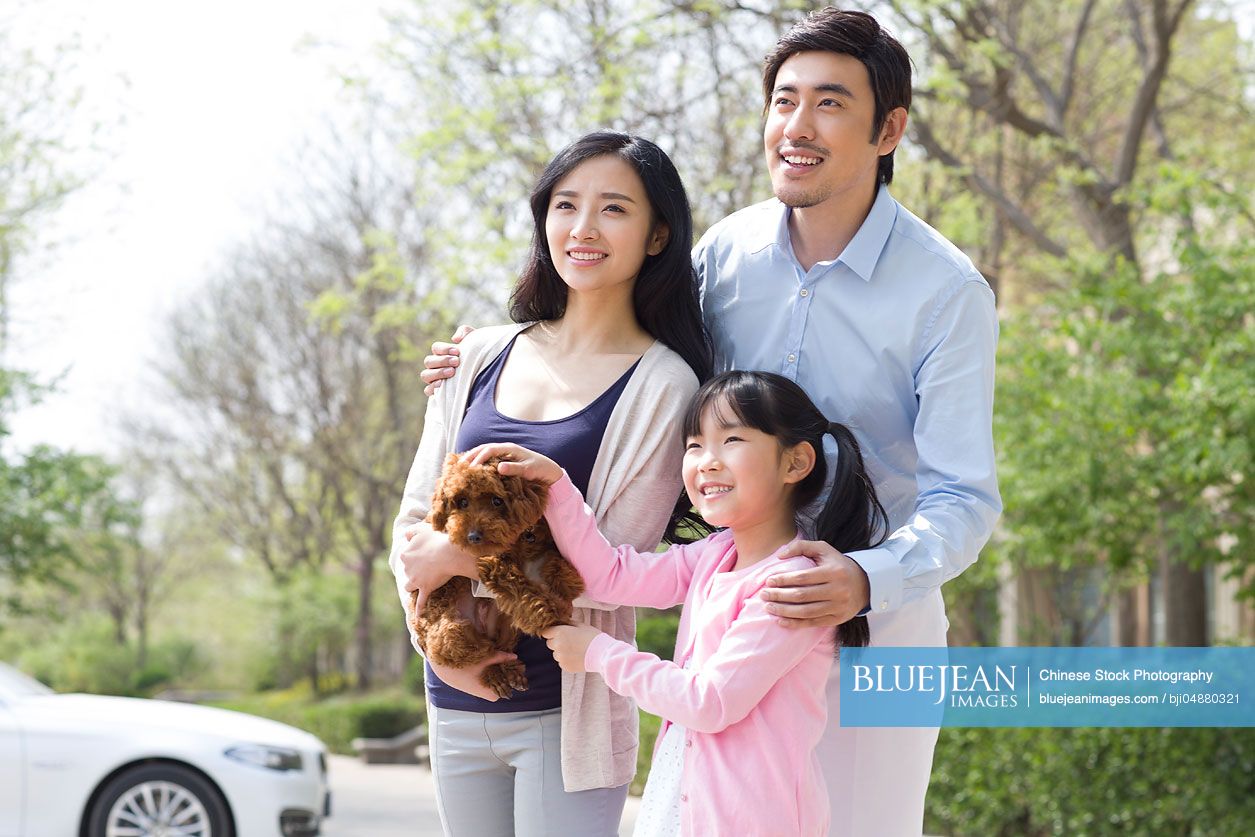 Happy young Chinese family with their pet dog