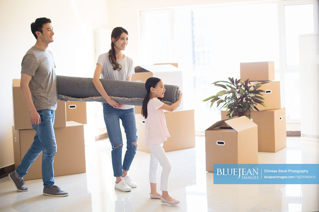 Happy young Chinese family moving to a new house