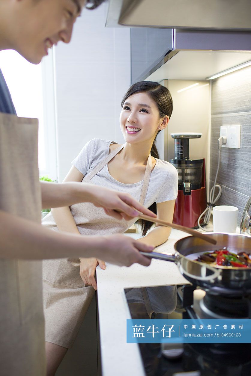 快乐的年轻夫妇在厨房做饭