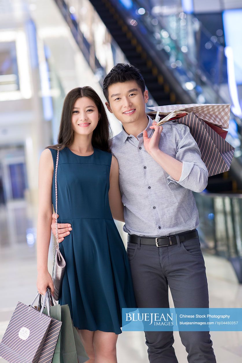 Happy young Chinese couple shopping