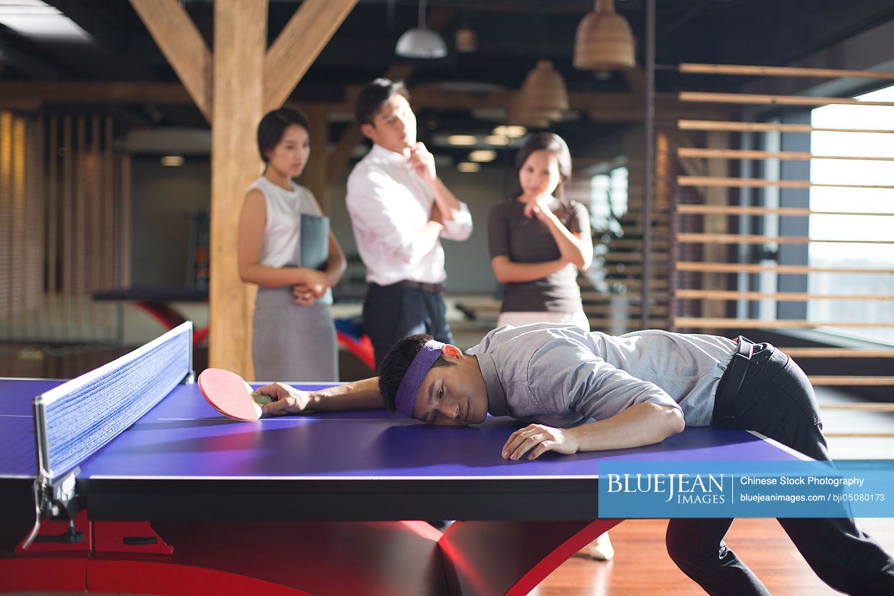 Young Chinese businessman playing ping pong