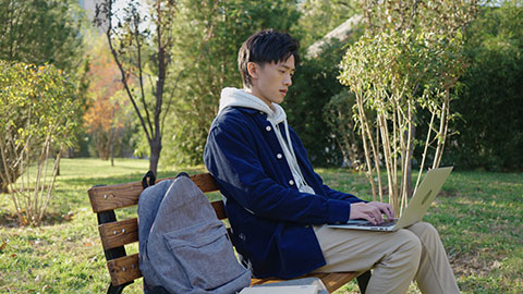 Chinese college boy using laptop