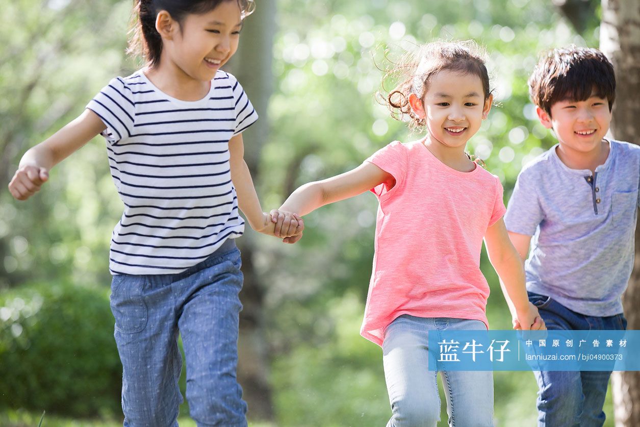 儿童手牵手在树林里奔跑