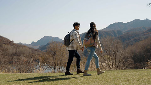 Happy young Chinese family hiking outdoors