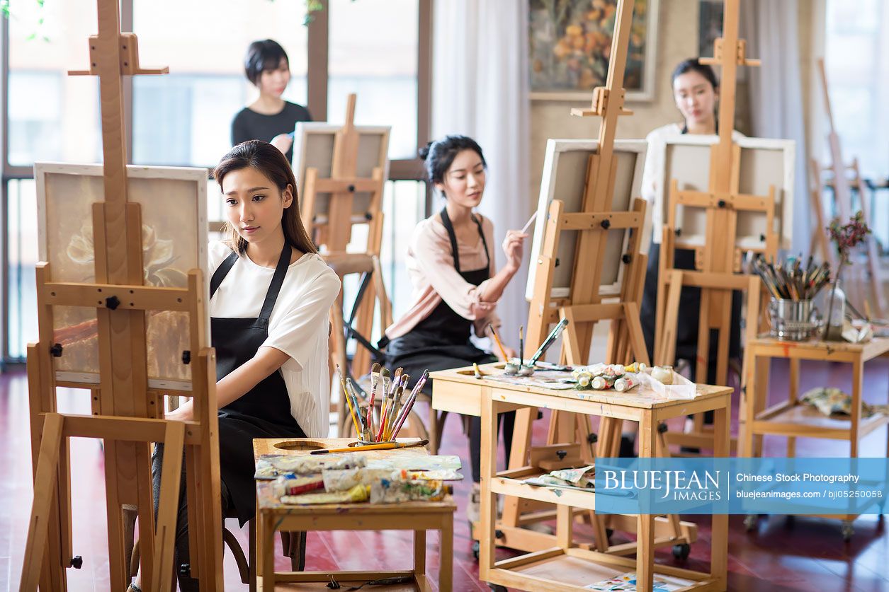 Young Chinese women painting in art class