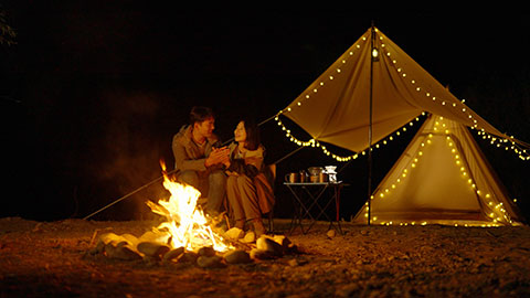 Happy young Chinese couple camping outdoors