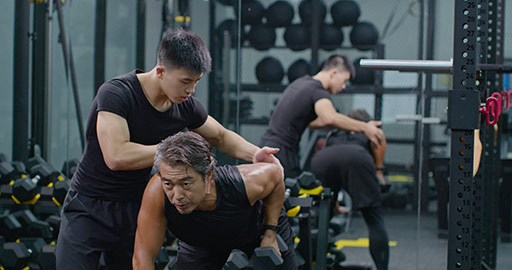 Mature Chinese man working out with personal trainer at gym,4K