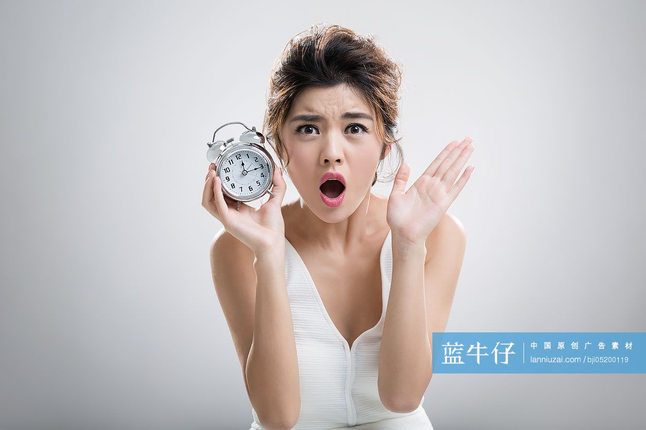 年轻美女拿着一个闹钟