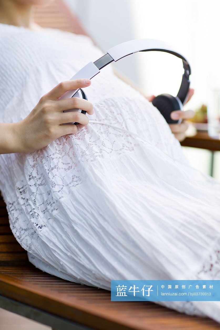 孕妇把耳机放在肚子上