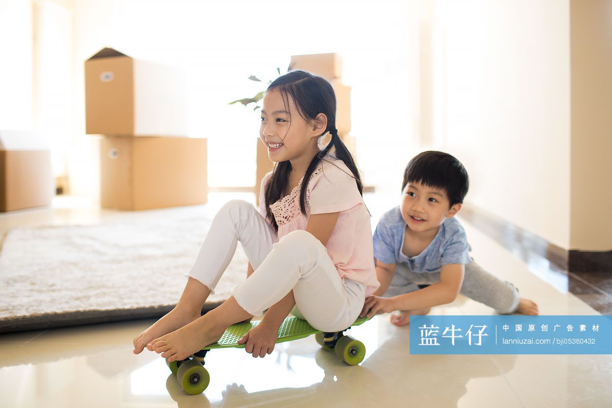 快乐的姐弟俩在新房里玩滑板