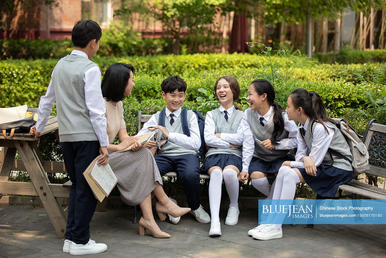 Chinese teacher talking with students on campus