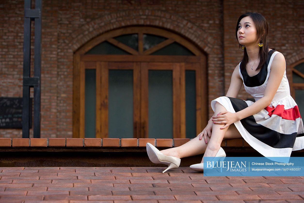 Young Chinese woman sitting on ground