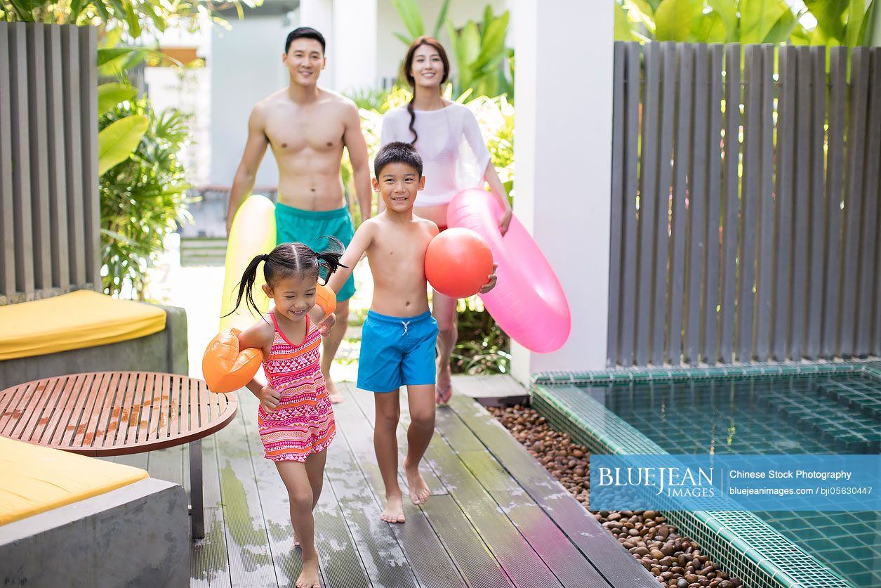 Happy young Chinese family going swimming