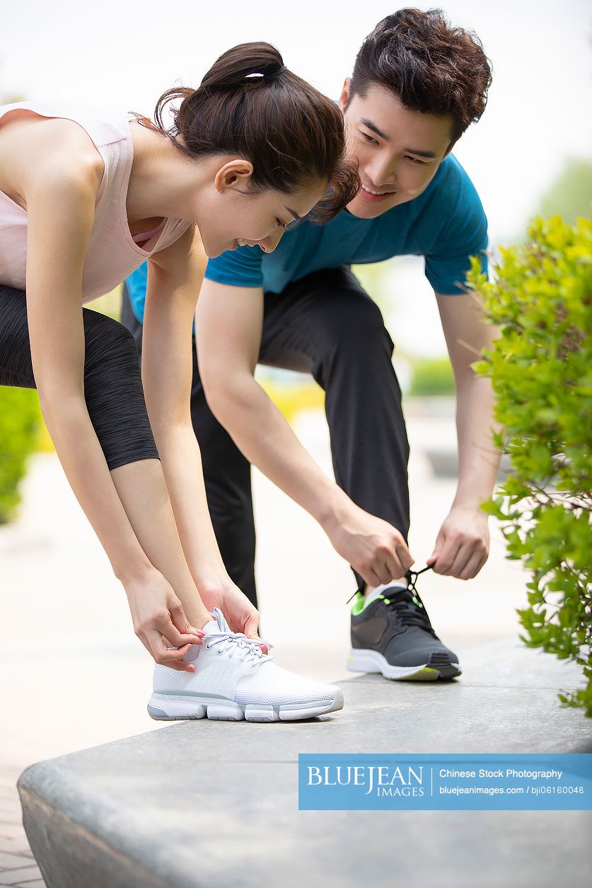 Happy young Chinese couple preparing for morning run