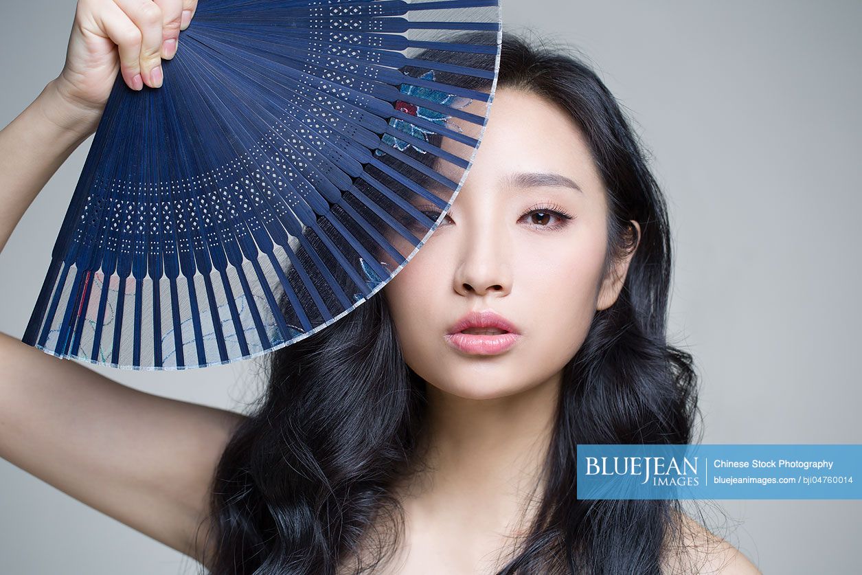 Beautiful young Chinese woman with folding fan