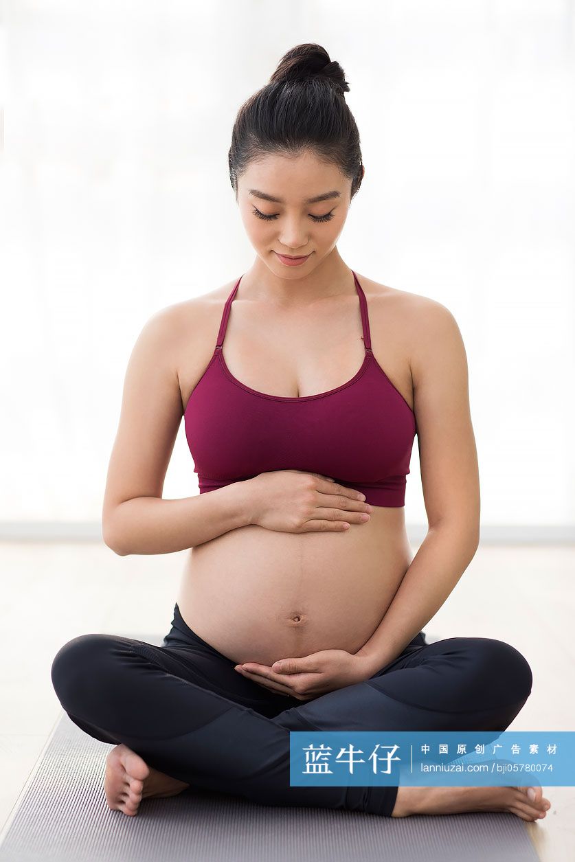 年轻孕妇手放在肚子上