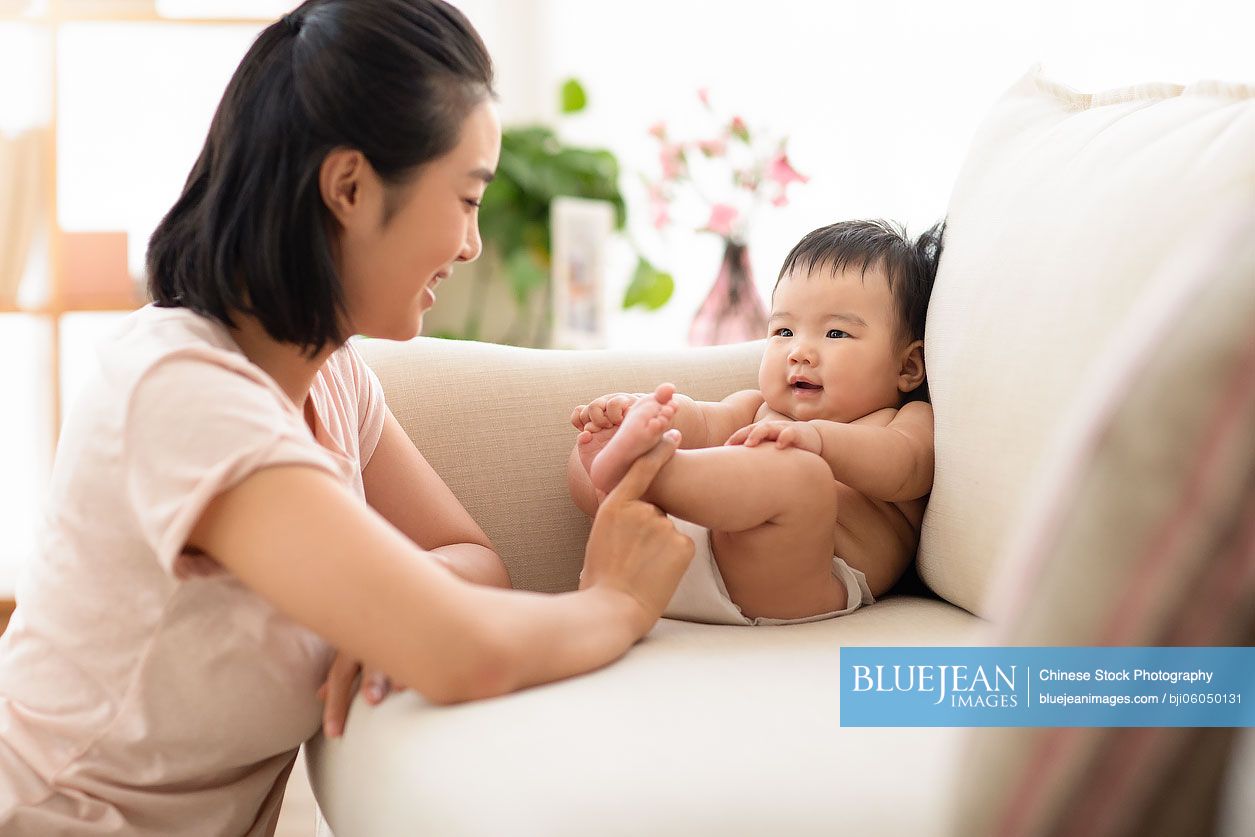 Young Chinese mom playing with her baby girl