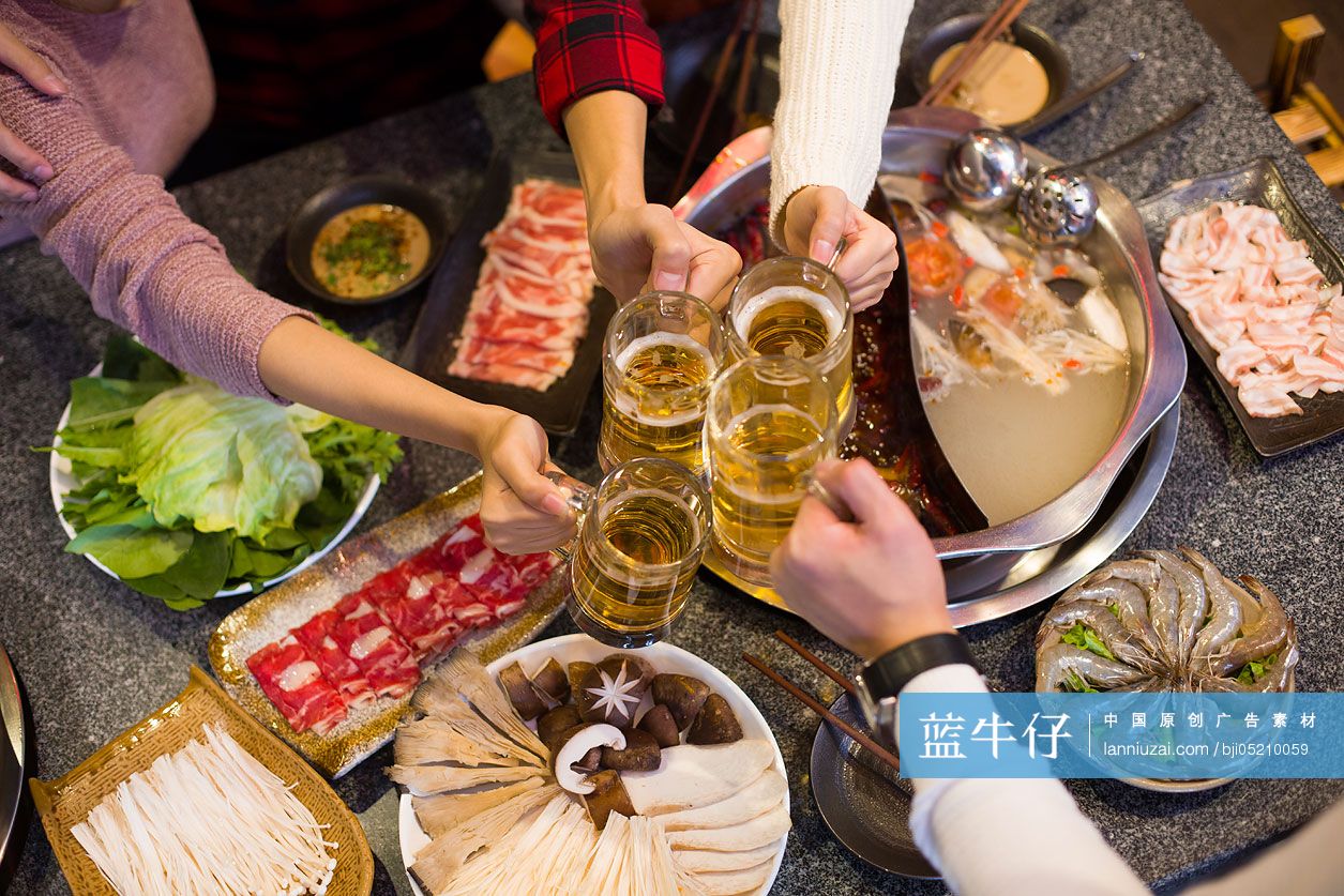 年轻朋友们在火锅店吃饭喝啤酒