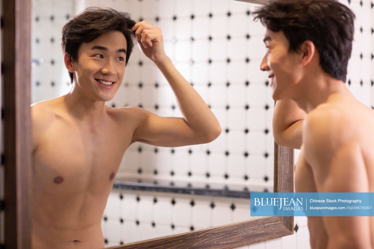 Young Chinese man in front of a mirror