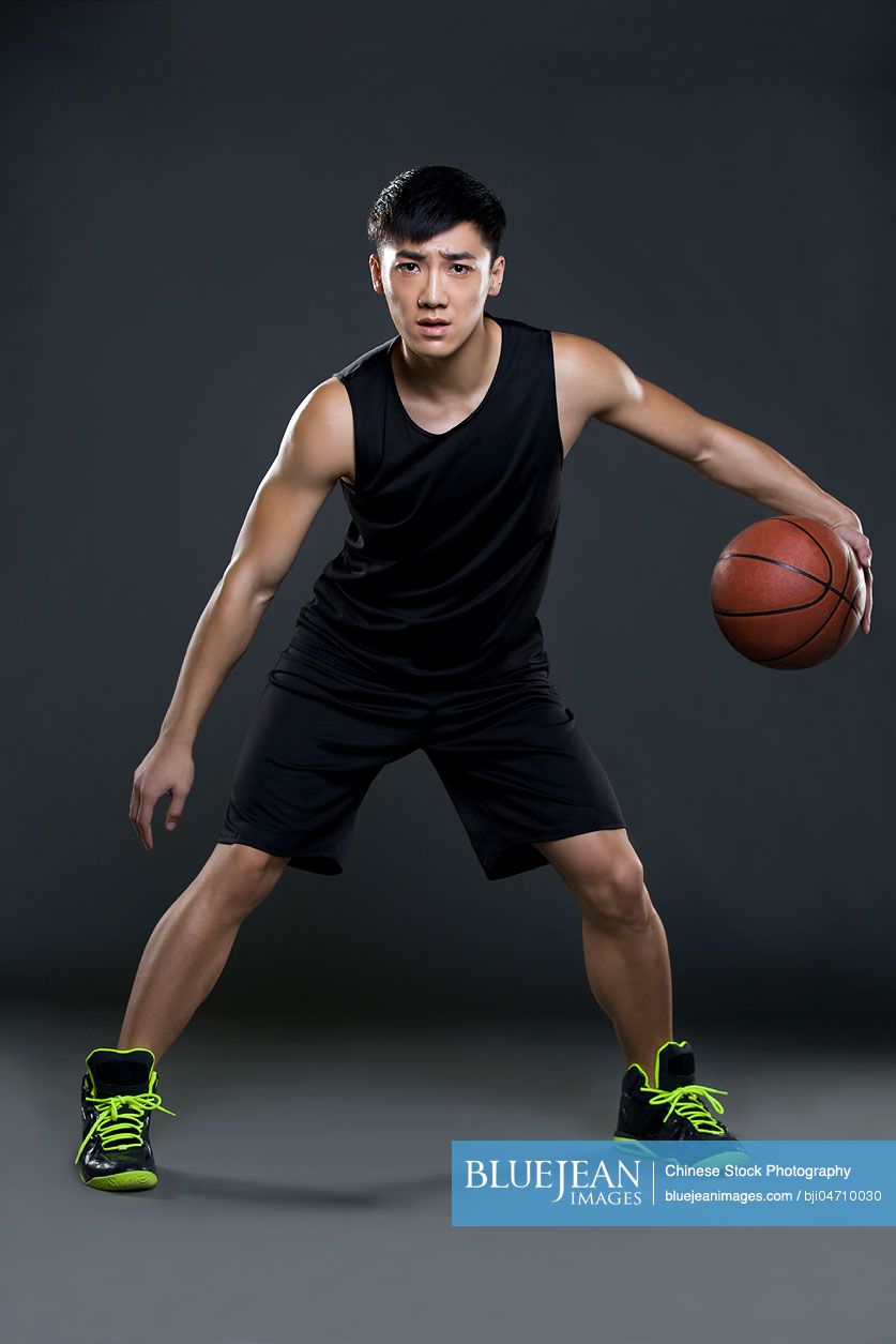 Young Chinese man playing basketball