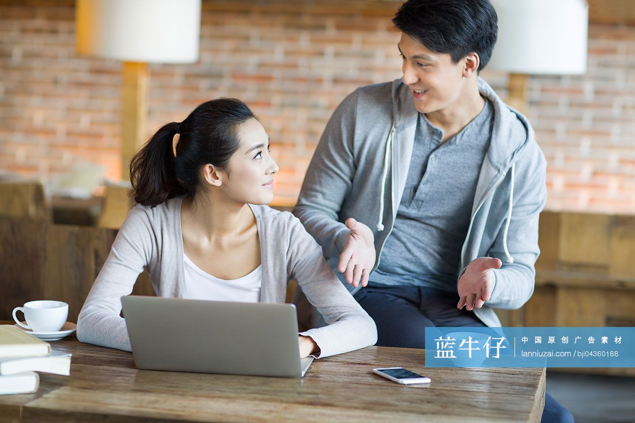 年轻情侣在咖啡馆使用笔记本电脑-蓝牛仔影像-中国原创广告影像素材