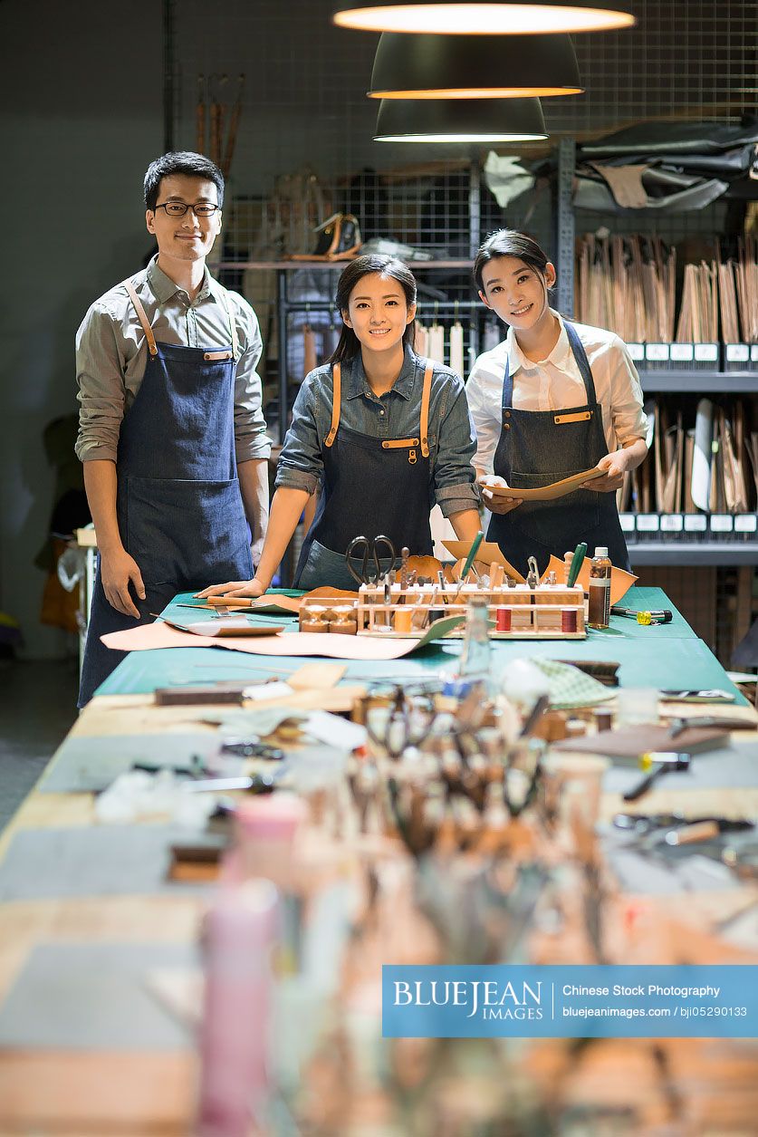 Portrait of confident Chinese leather craftspeople in studio 