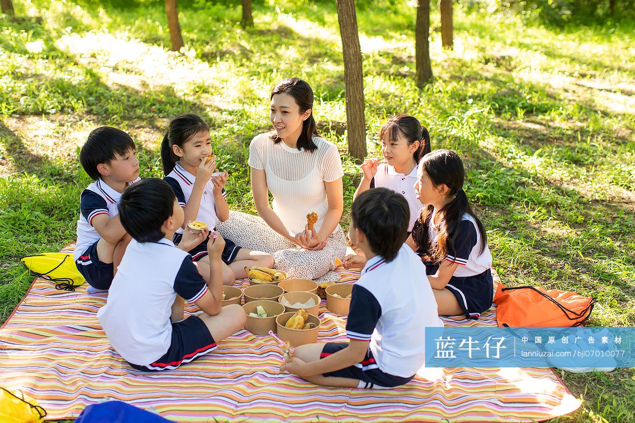 快乐的小学生和老师在户外野餐