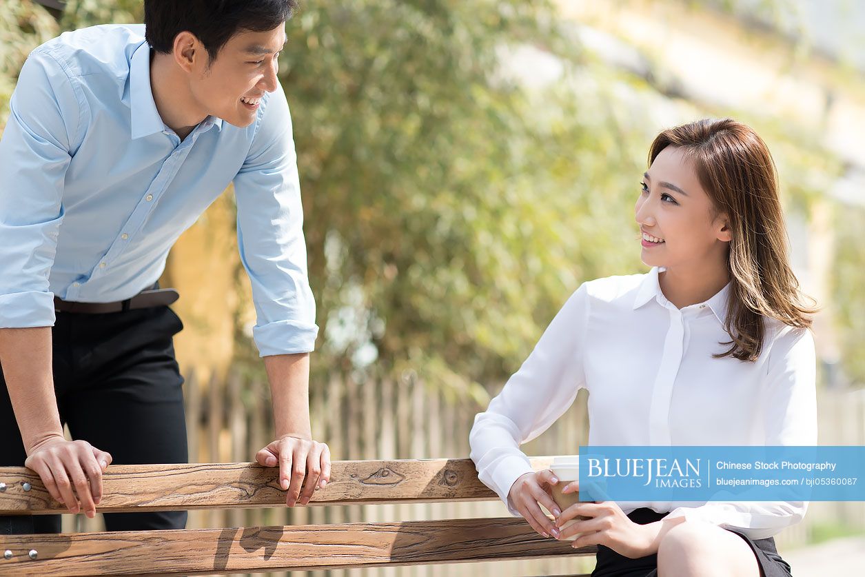 Young Chinese business people chatting outdoors