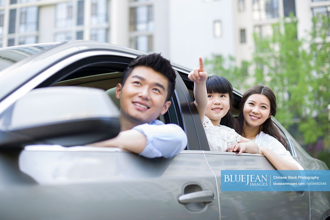 Happy young Chinese family in a car
