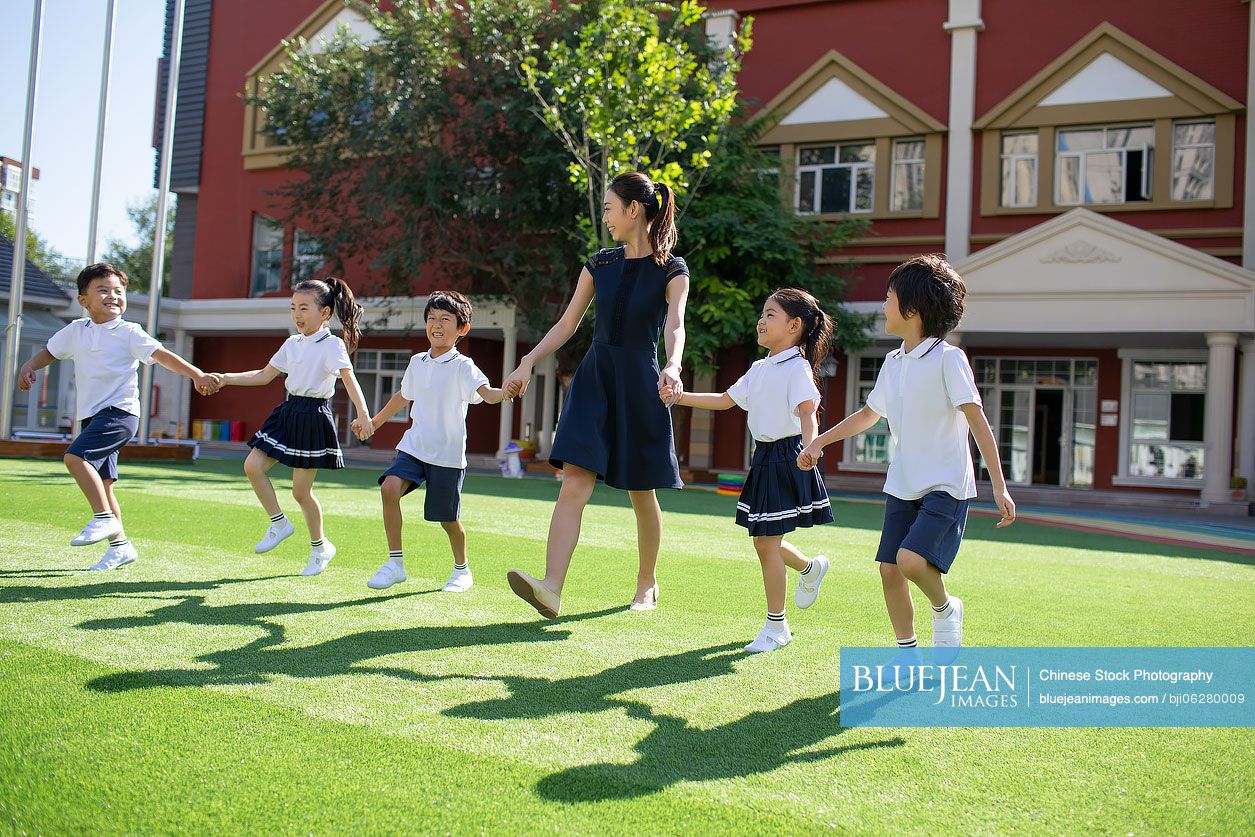 Chinese teacher and students in kindergarten playground