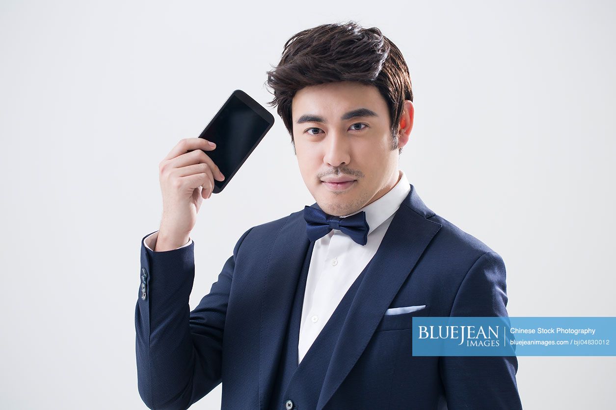 Young Chinese man holding a smart phone