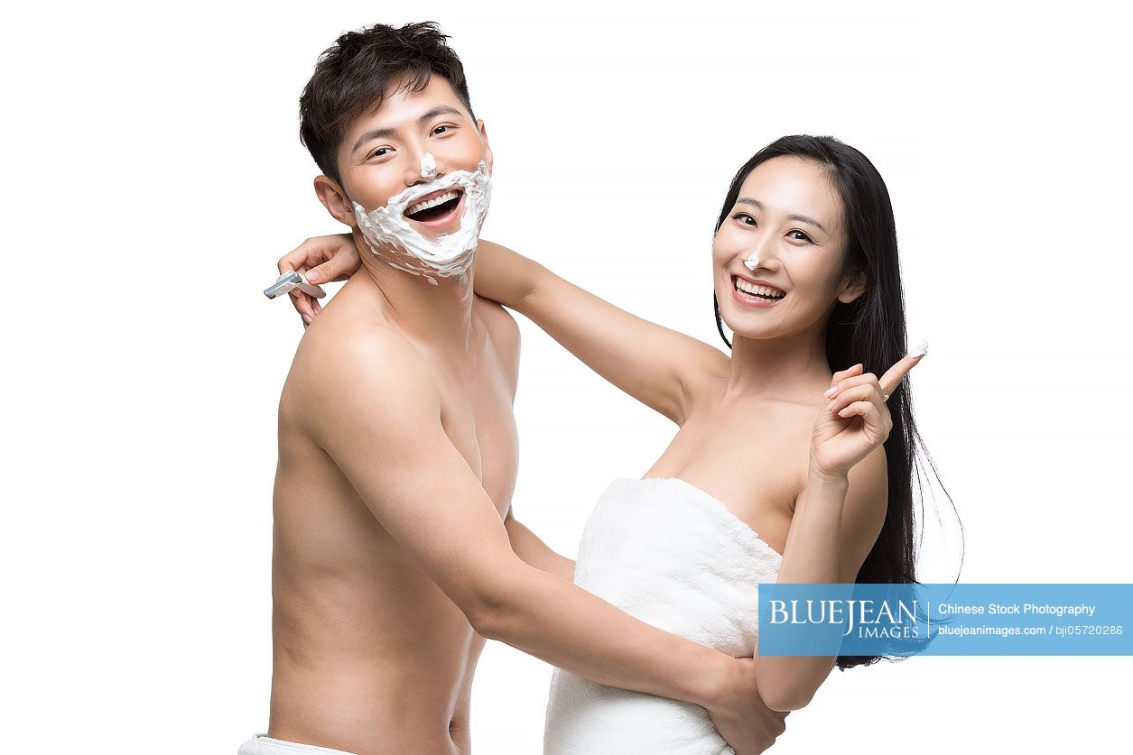 Young Chinese woman shaving her husband