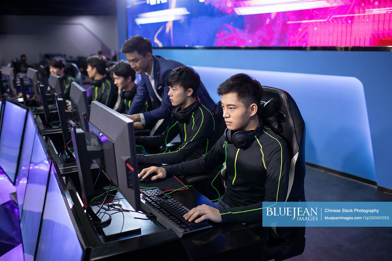 Young Chinese man coaching gamer playing esports