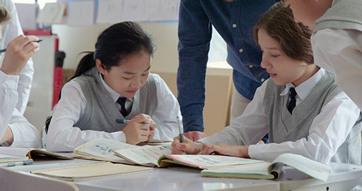 Young foreign teacher helping students in class,4K