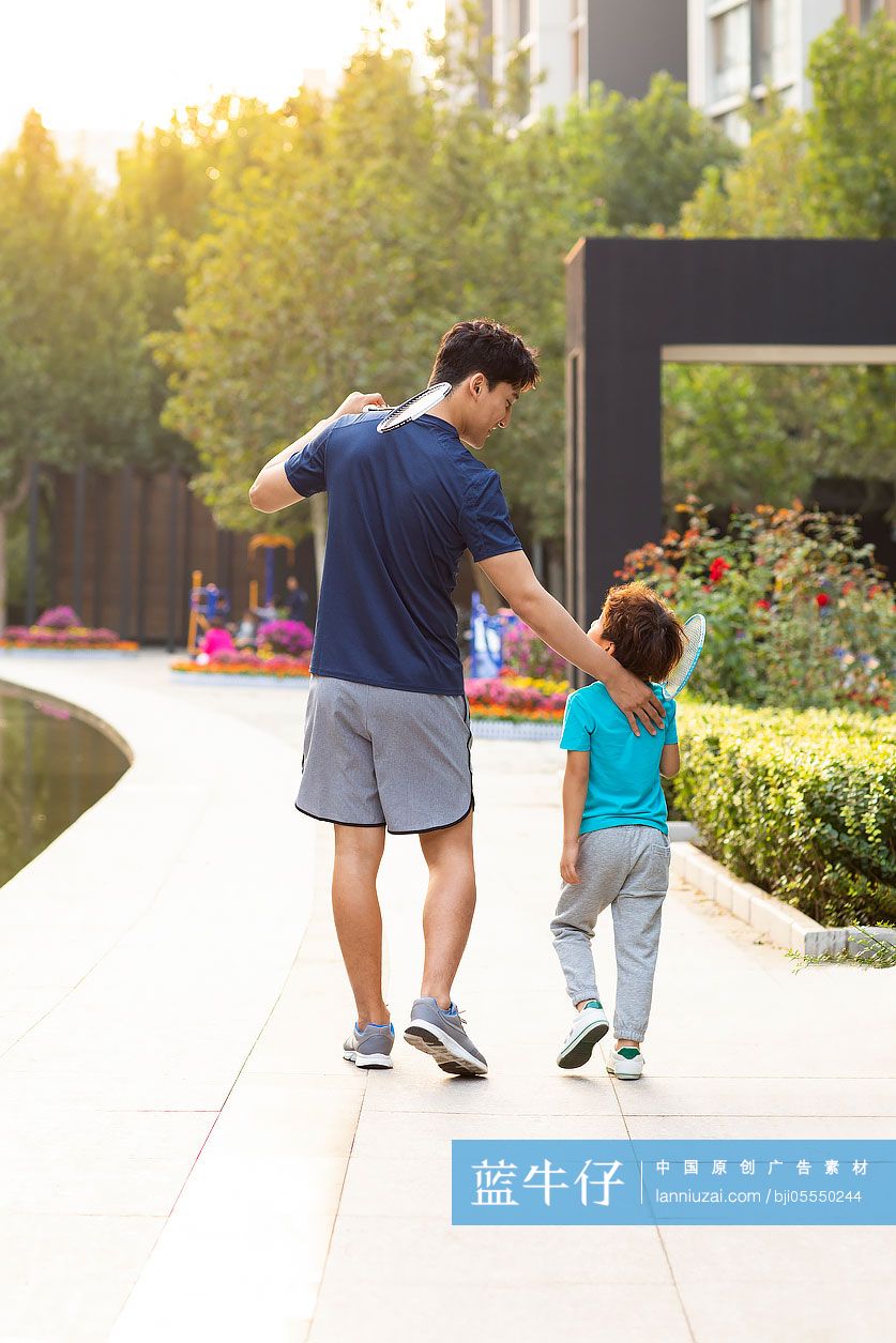 开心的父子俩来公园打羽毛球