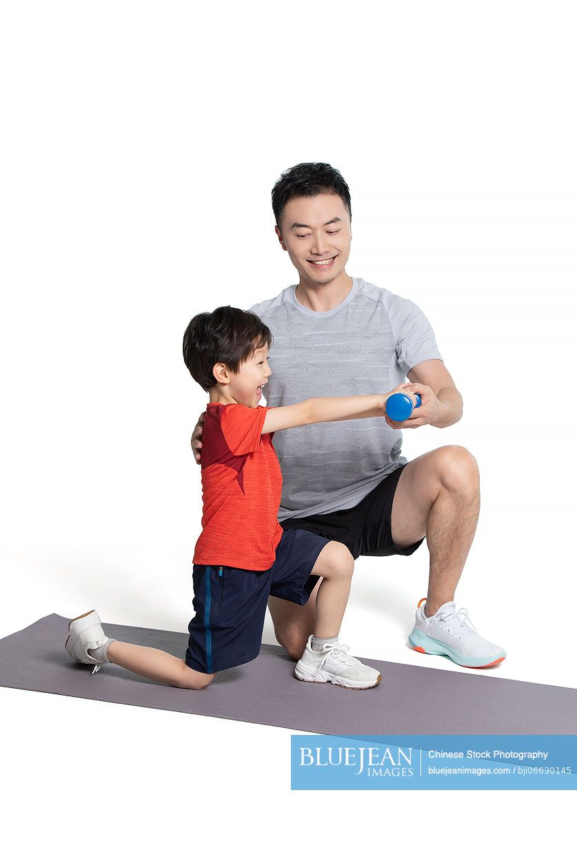 Little Chinese boy exercising with his father