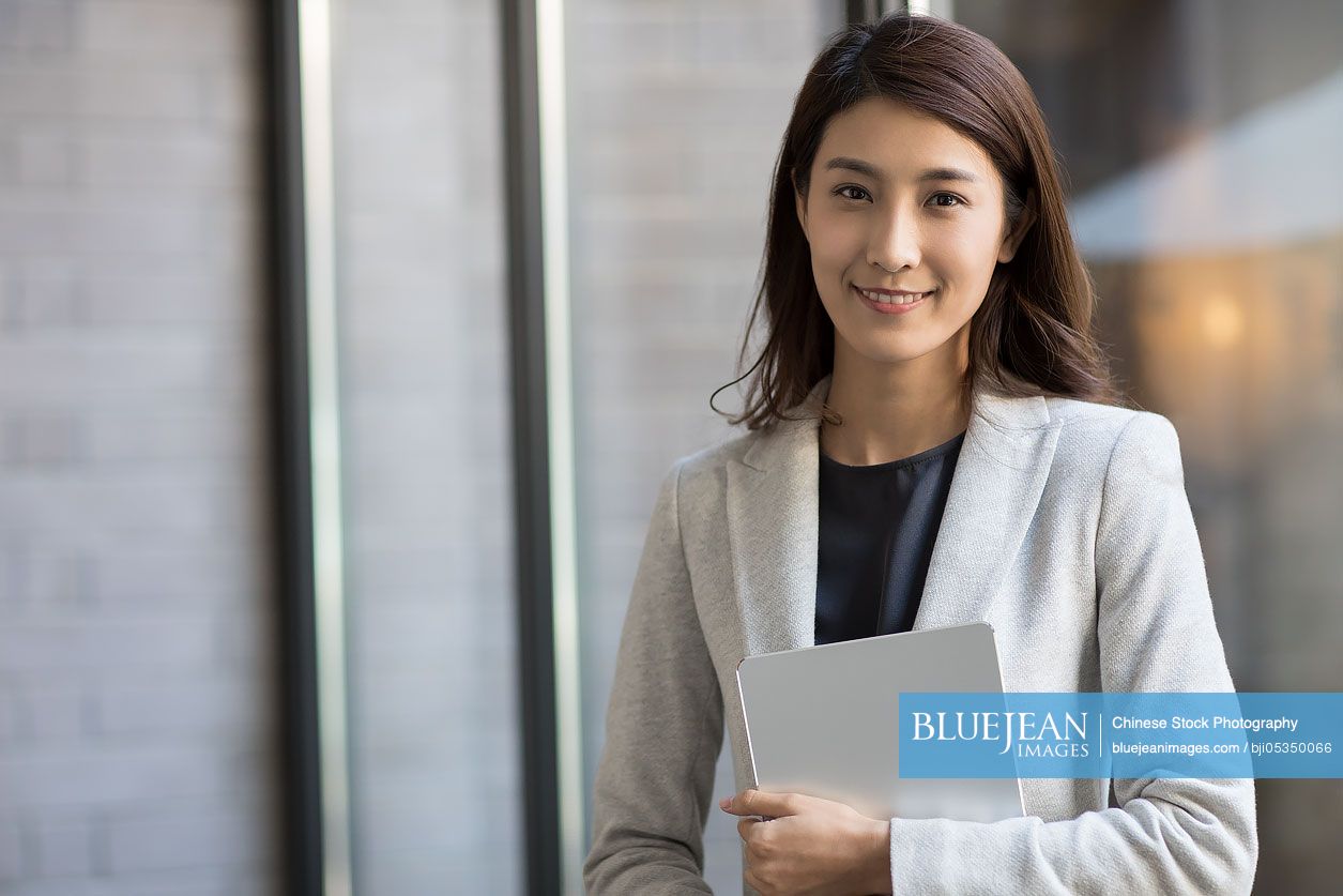 Young Chinese businesswoman holding a digital tablet