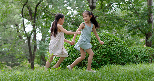Two little Chinese girls playing on grass,4K