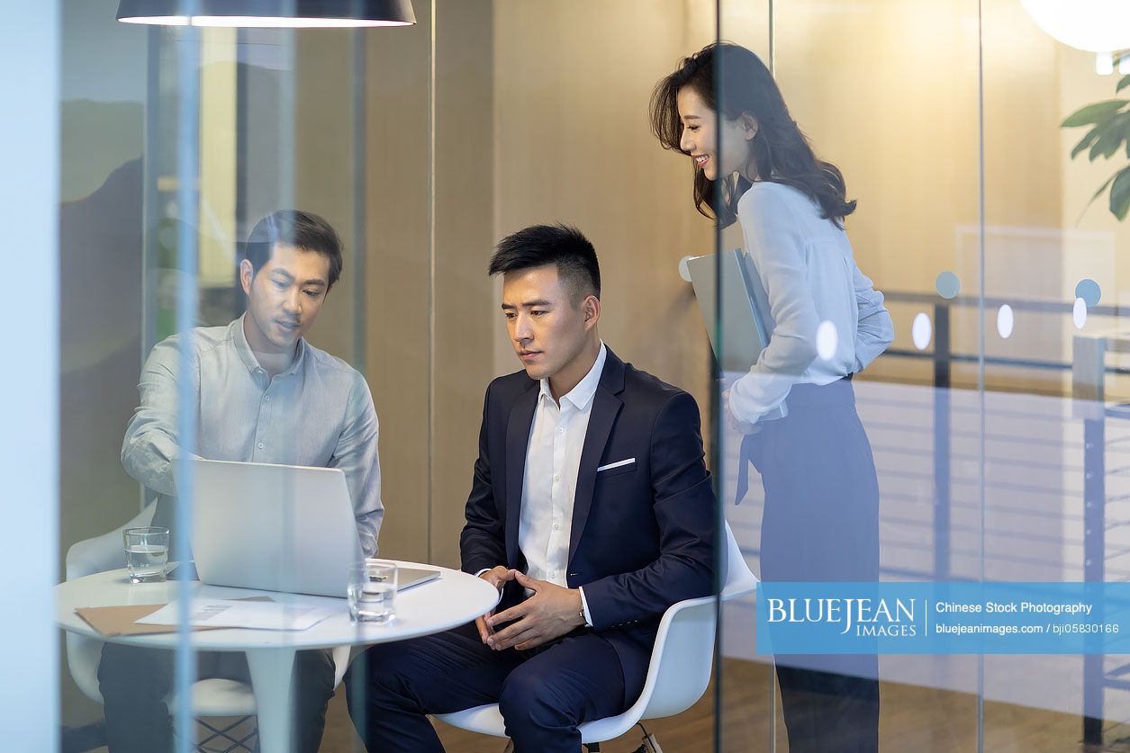 Confident Chinese business people talking in the office