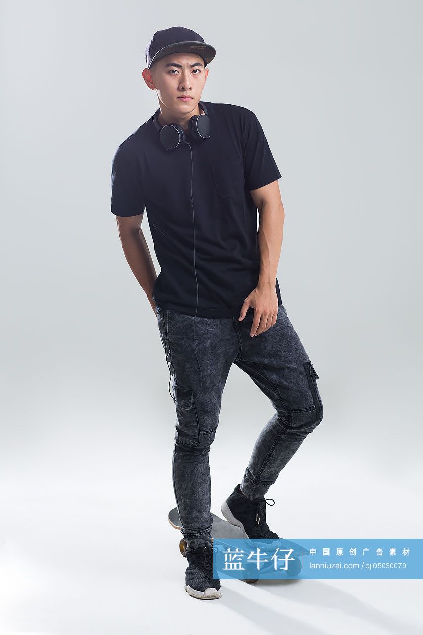 戴耳机的年轻男子在滑滑板