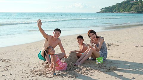 Happy young Chinese family having fun on beach,4K