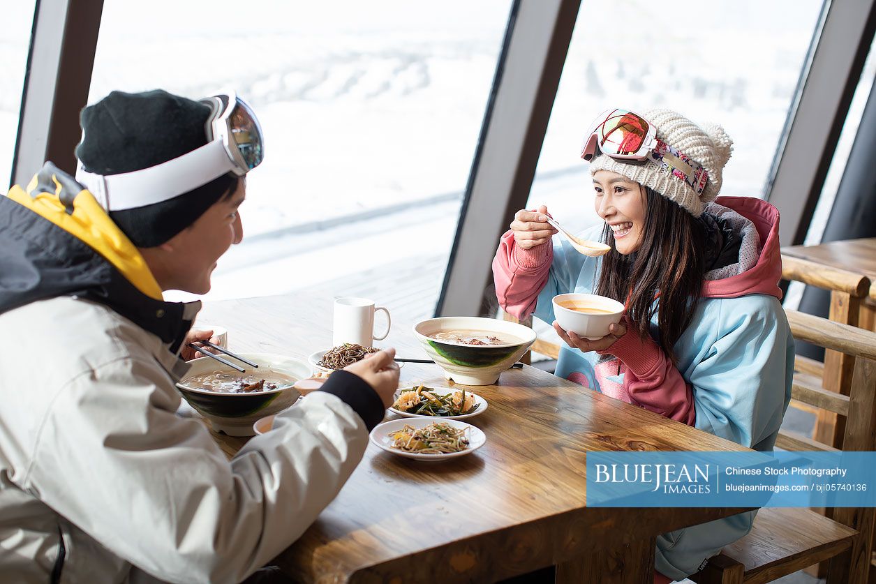 Happy young couple dining in restaurant