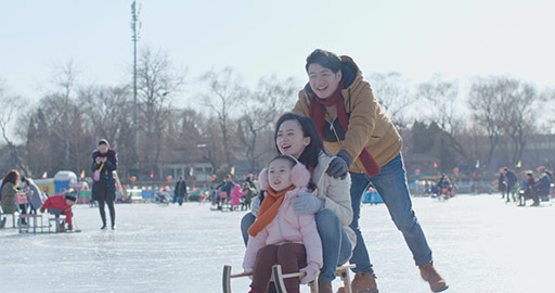 年轻家庭在冰上玩耍