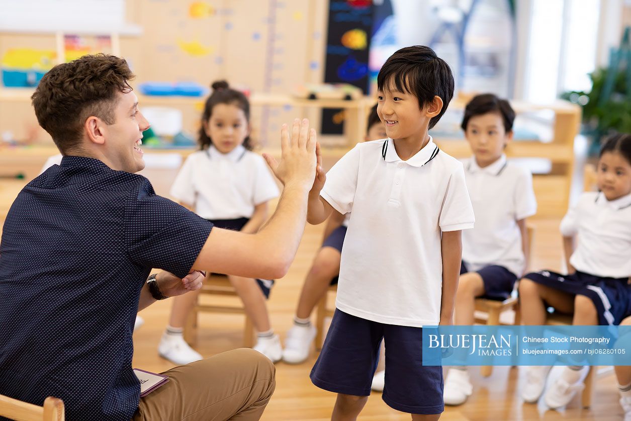 Foreign teacher teaching children English in classroom