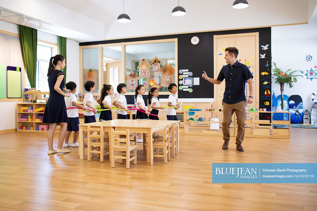 Teachers and children playing games in classroom