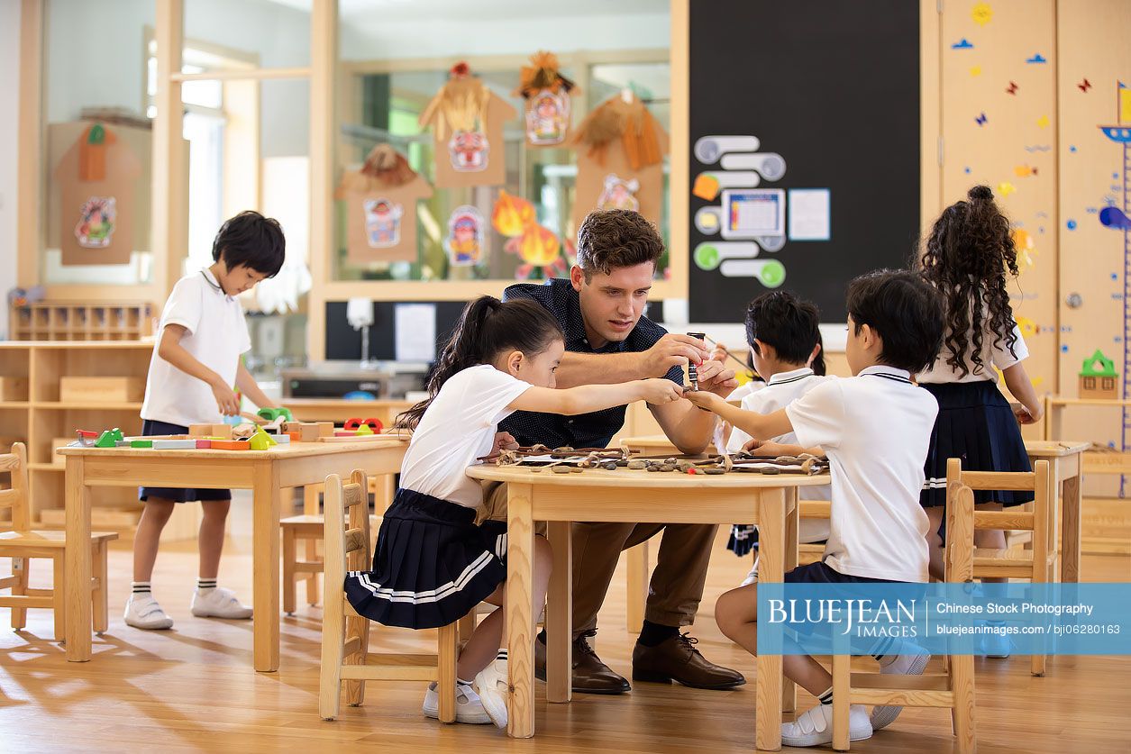 Foreign teacher and children playing in classroom